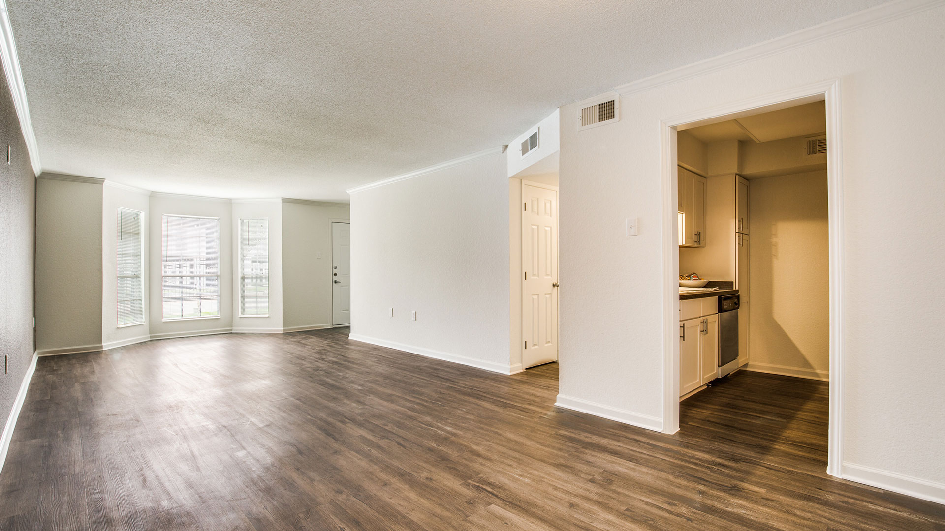 an empty room with hardwood floors and a white door at The WESTON