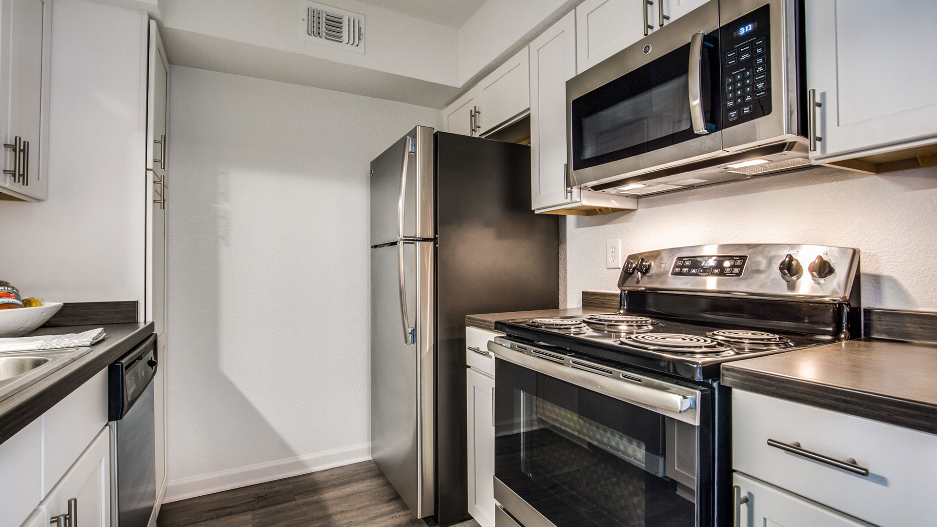 a kitchen with stainless steel appliances and a microwave at The WESTON