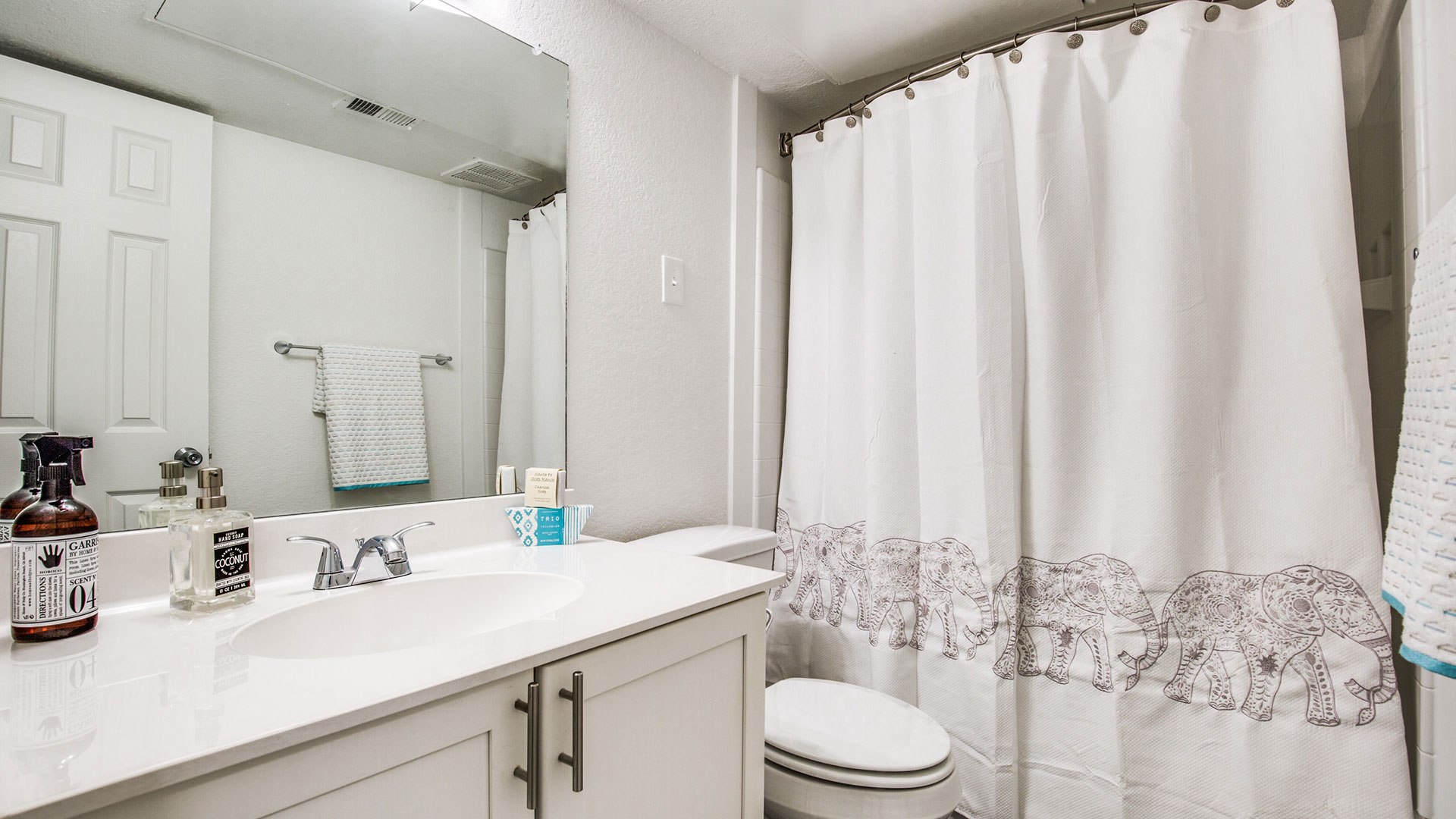 a bathroom with a shower curtain and toilet at The WESTON