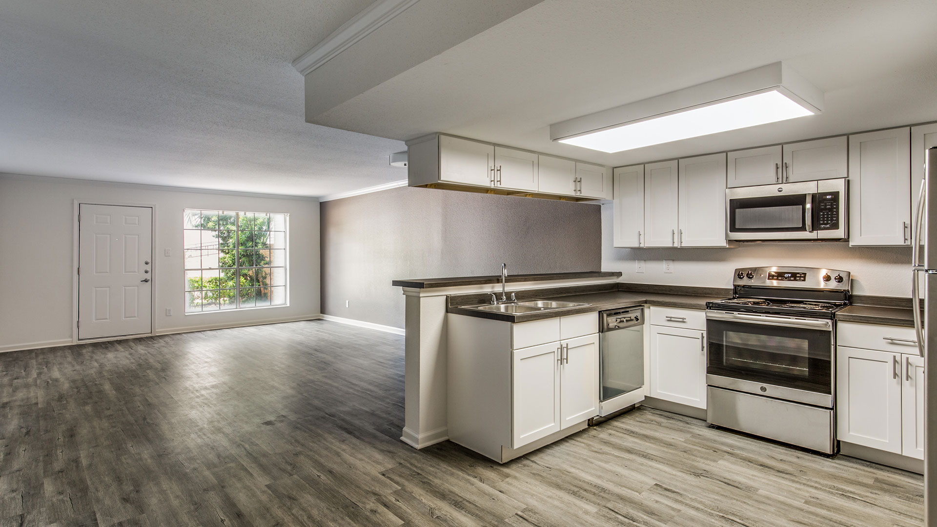 a clean kitchen with white cabinets and stainless steel appliances at The WESTON