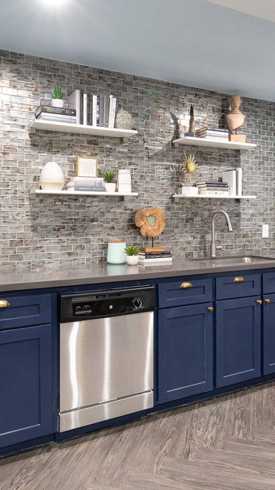a kitchen with blue cabinets and a white counter at The WESTON
