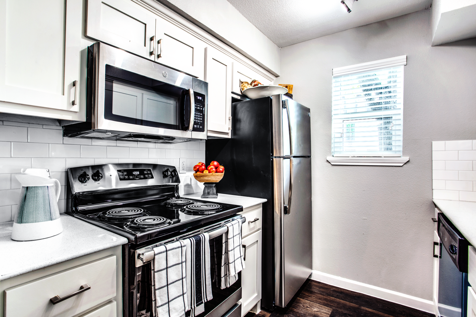 a kitchen with a stove, microwave, refrigerator and sink at The WESTON