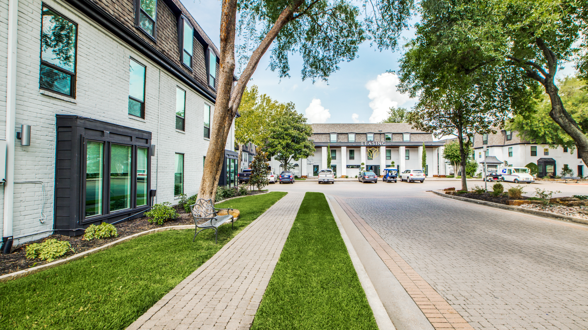 a street with grass and trees in front of a building at The WESTON