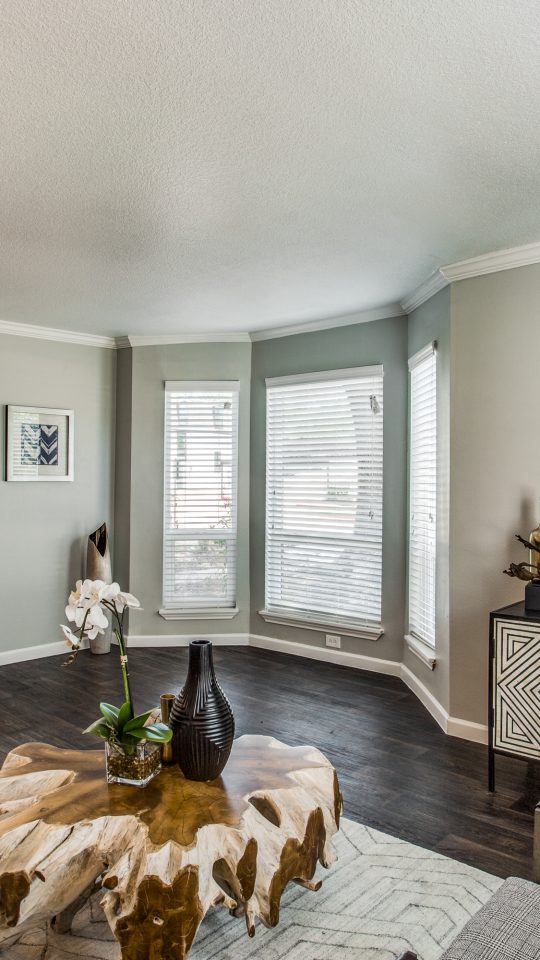 a living room with hardwood floors and a large window at The WESTON
